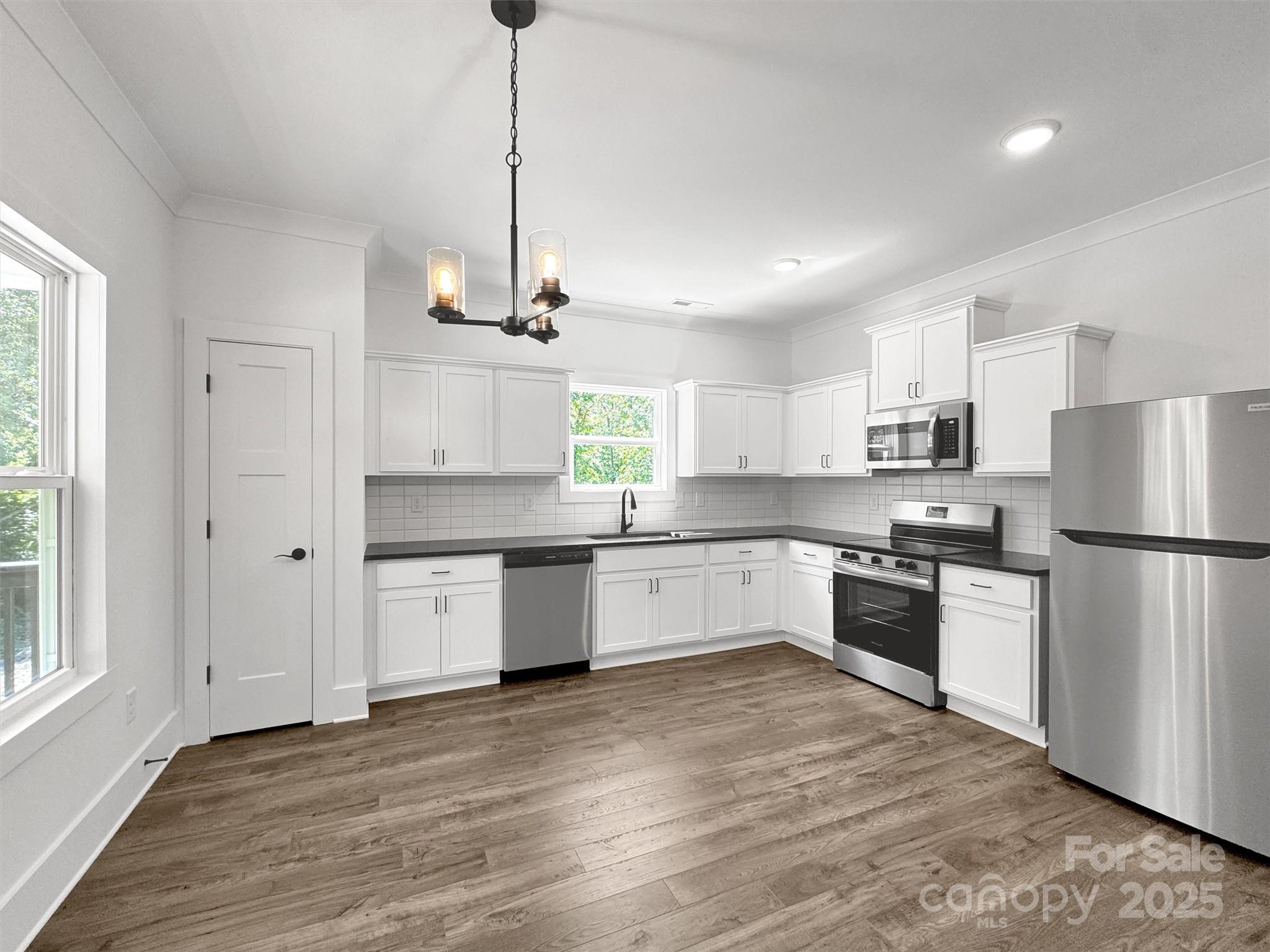 12 Whitson Road Asheville, NC 28805 - Photo 3 of 18 a kitchen with granite countertop a refrigerator a sink dishwasher a stove and white cabinets with wooden floor