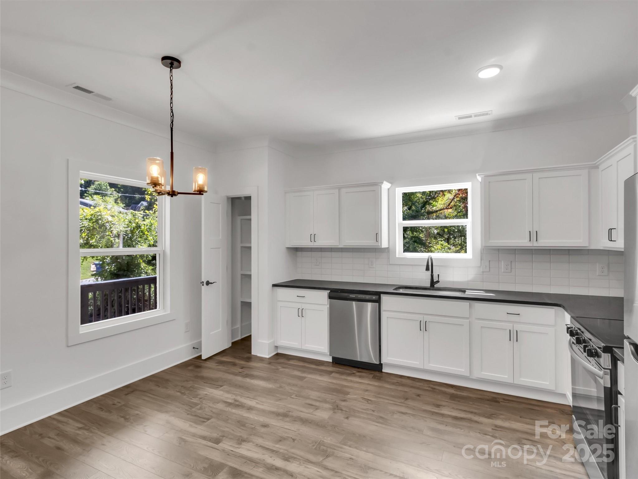 12 Whitson Road Asheville, NC 28805 - Photo 4 of 18 a kitchen with stainless steel appliances granite countertop a sink a stove a refrigerator and island with wooden floor
