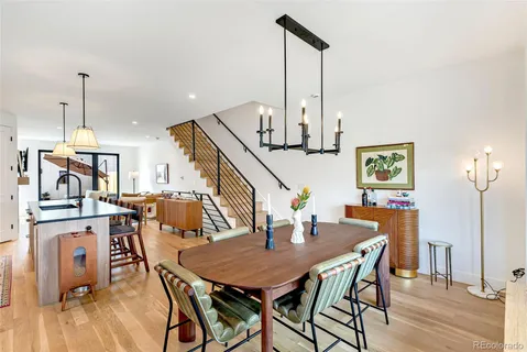 a dining room filled chandelier and wooden floor