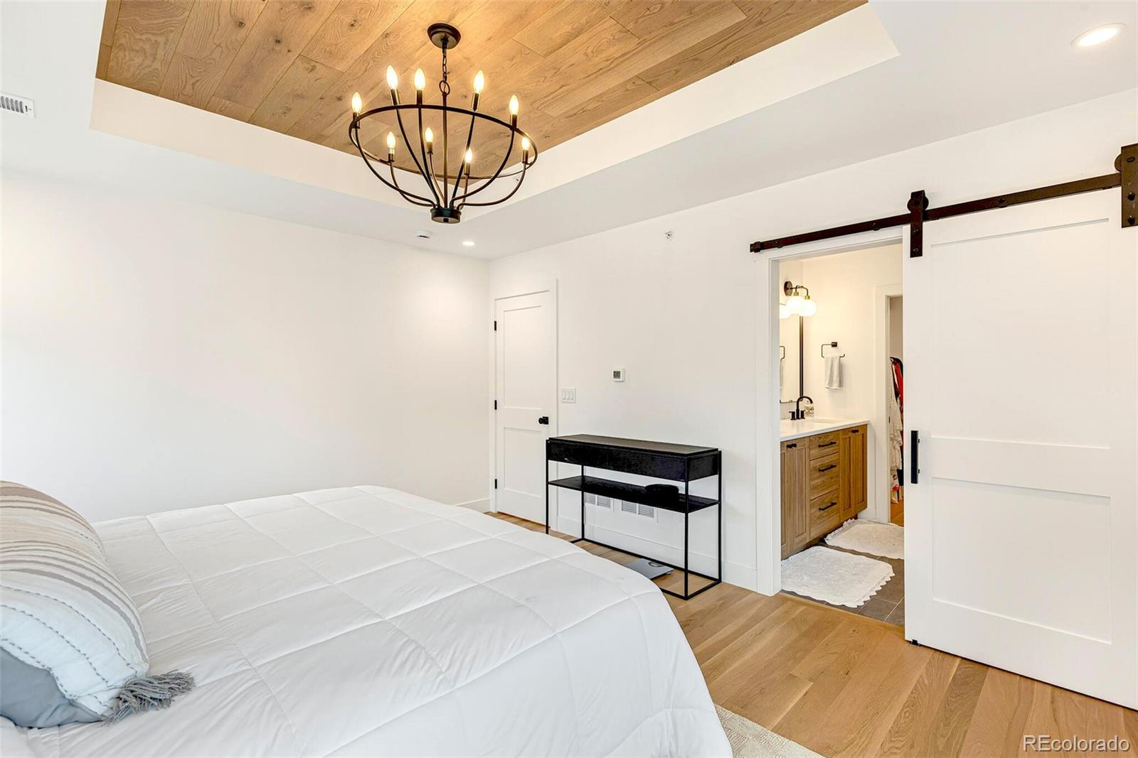 2455 Chase Street Edgewater, CO 80214 - Photo 20 of 46 a bedroom with a bed and a chandelier
