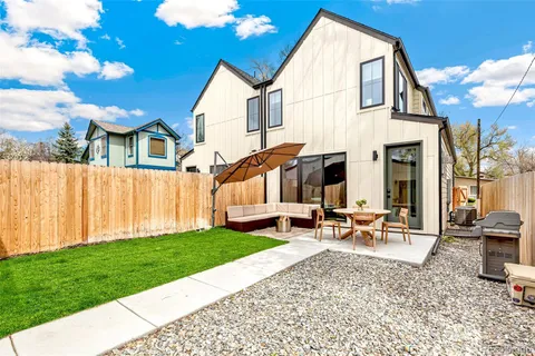 a view of a house with backyard and sitting area