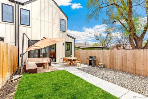a view of a patio with a table and chairs under an umbrella