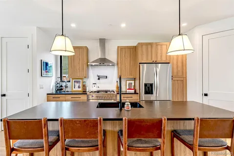 a dining table chairs and a refrigerator in kitchen