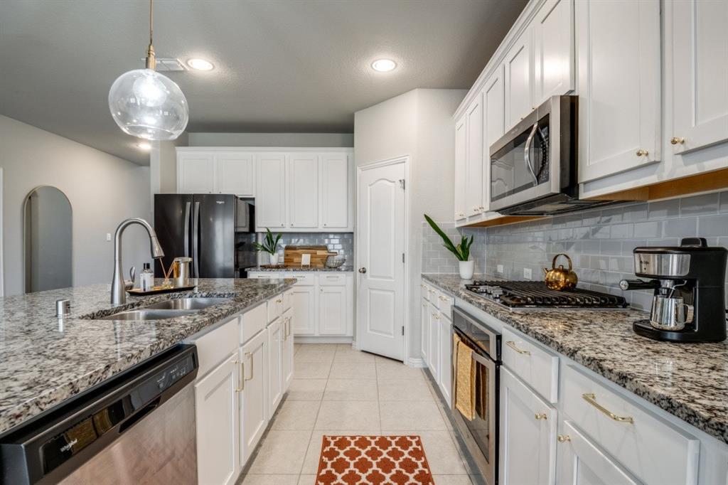 1316 Torrington Lane Forney, TX 75126 - Photo 13 of 36 a kitchen with stainless steel appliances granite countertop a sink and stove