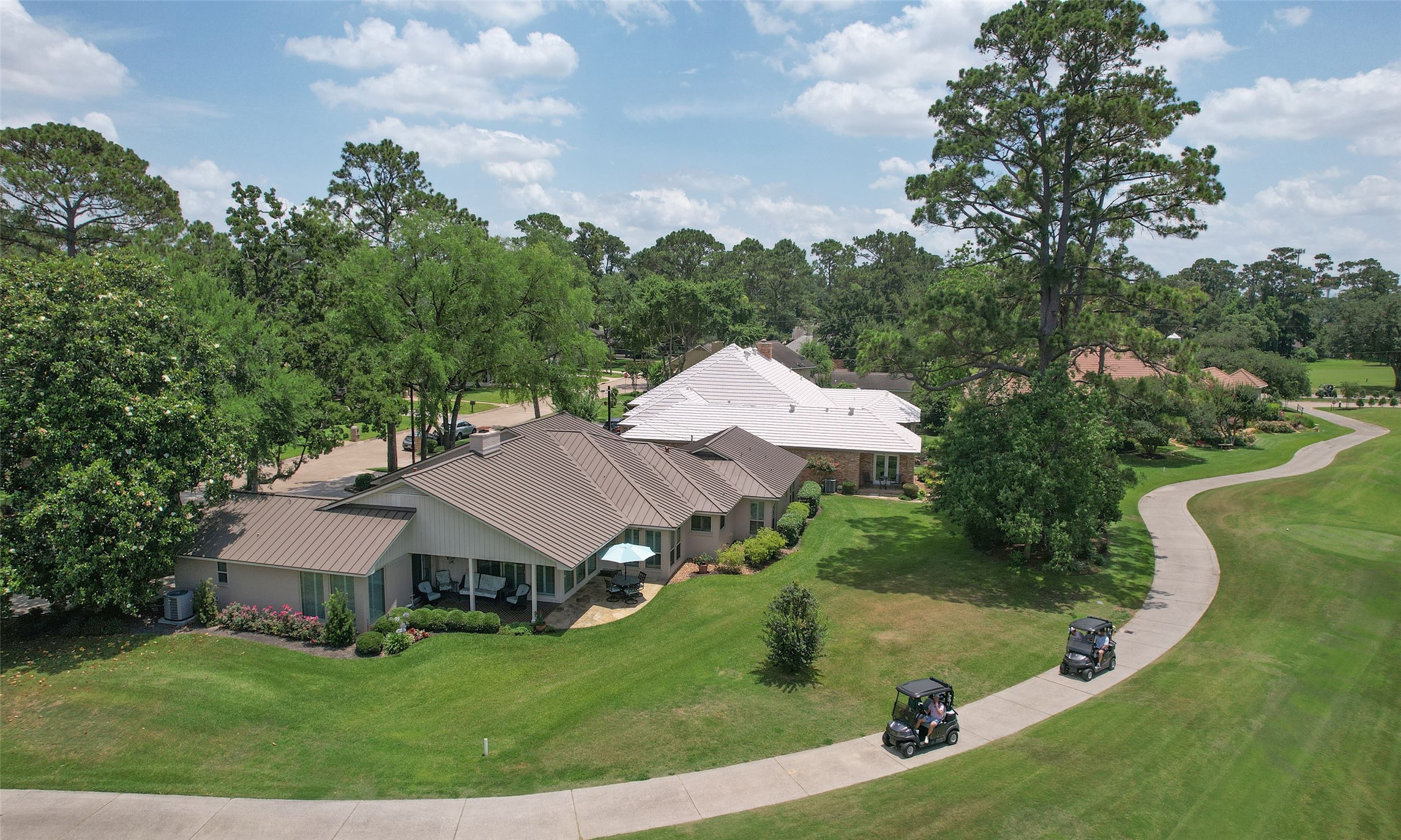 an aerial view of residential houses with outdoor space and trees
