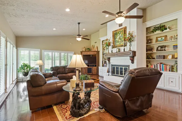 a living room with furniture fireplace and a large window