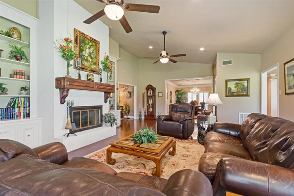 a living room with furniture a chandelier and a fireplace