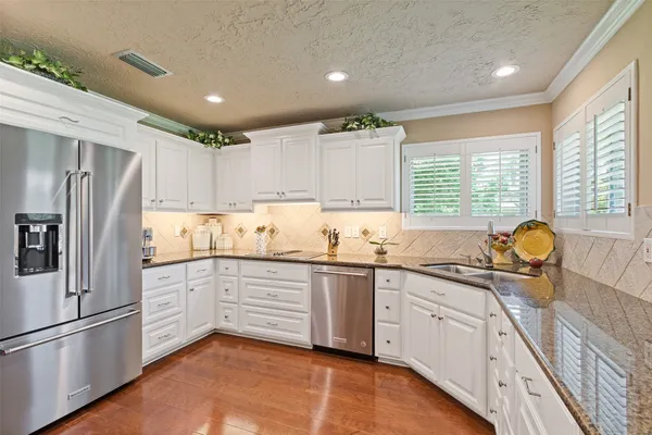 a kitchen with granite countertop stainless steel appliances a sink and cabinets