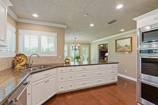 a kitchen with granite countertop a stove and cabinets