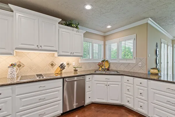 a kitchen with granite countertop white cabinets and white appliances