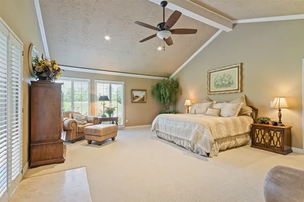 a spacious bedroom with a bed couch and a window
