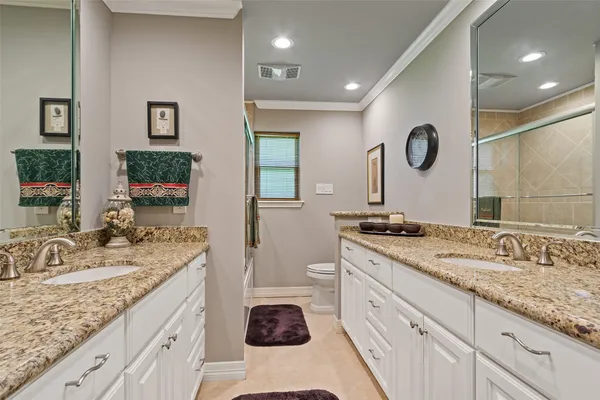 a bathroom with a granite countertop double vanity sink and a mirror