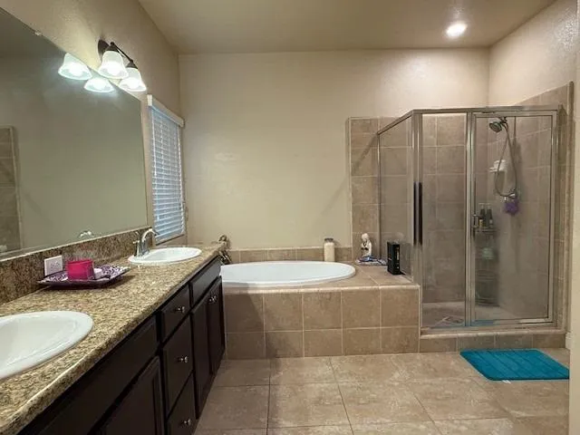 a bathroom with a granite countertop tub a sink and a mirror