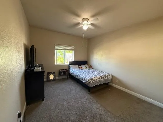 a bedroom with a bed and a ceiling fan