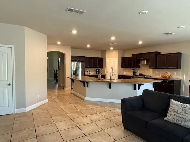a kitchen with stainless steel appliances granite countertop a refrigerator and a stove top oven