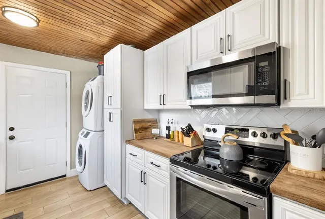 a kitchen with stainless steel appliances granite countertop a stove a refrigerator and a microwave