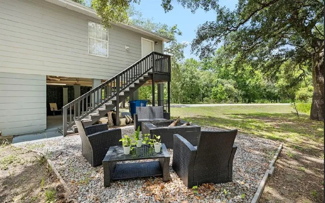 a view of a patio with couches chairs and a yard