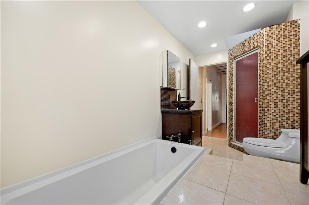 413 A 6th Avenue Brooklyn, NY 11215 - Photo 21 of 30 a bathroom with a tub a sink and a shower