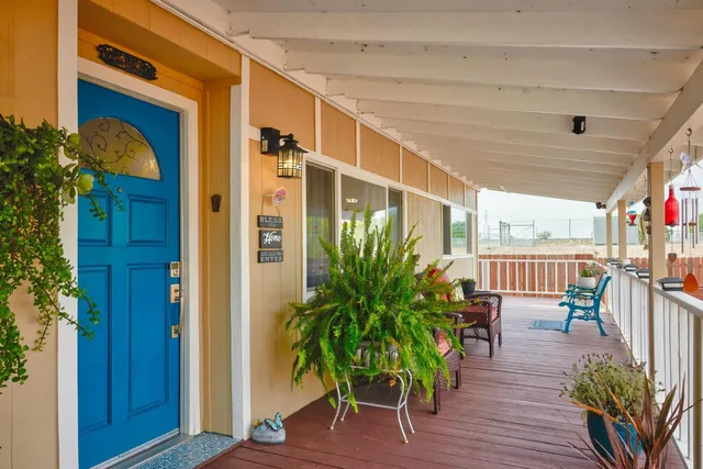a porch with chairs and potted plants