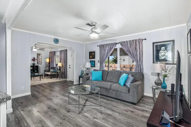 a living room with furniture and a wooden floor