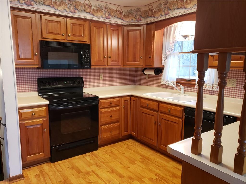 2525 Moore's Corner Road Volant, PA 16156 - Photo 6 of 40 a kitchen with stainless steel appliances granite countertop a stove microwave and sink