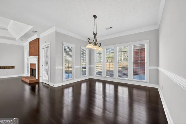 a view of empty room with wooden floor and floor to ceiling window