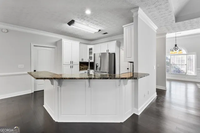 a kitchen with stainless steel appliances a sink a stove a refrigerator and cabinets
