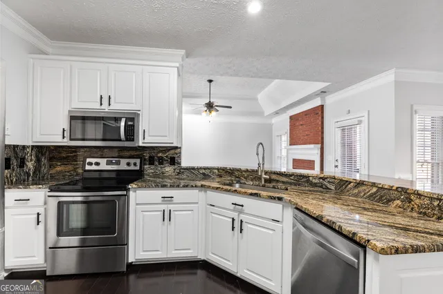 a kitchen with granite countertop a stove sink and cabinets