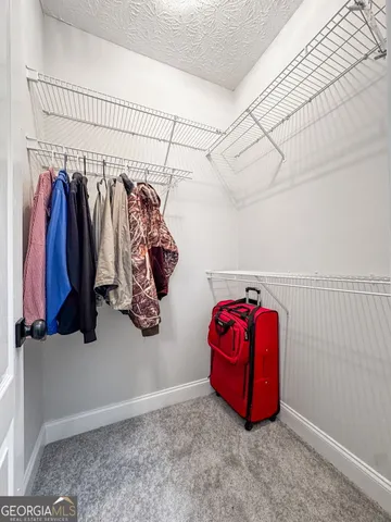 a view of walk in closet with clothes