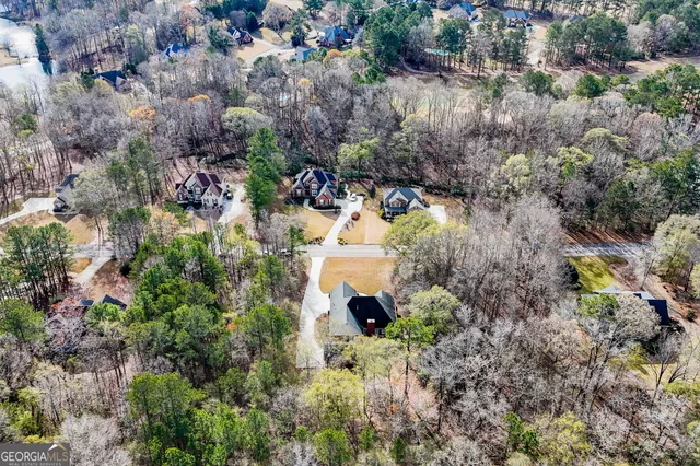 an aerial view of residential house with outdoor space and trees all around