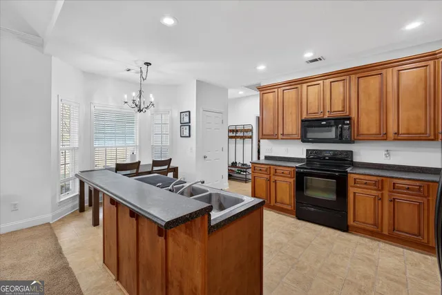 a kitchen with granite countertop a stove top oven a sink dishwasher and a refrigerator with wooden cabinets