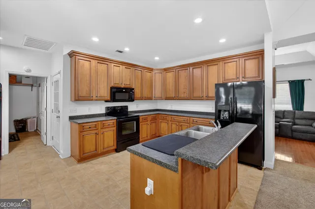 a kitchen with stainless steel appliances granite countertop a sink dishwasher stove and refrigerator