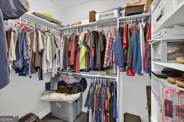 a view of walk in closet with clothes and shoes