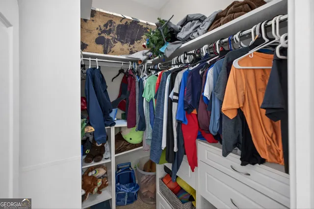 a view of walk in closet with clothes and shoes