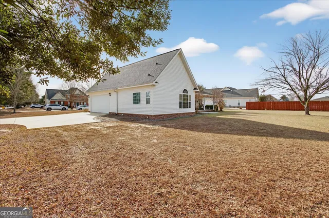 a backyard of a house with large trees and a parked car