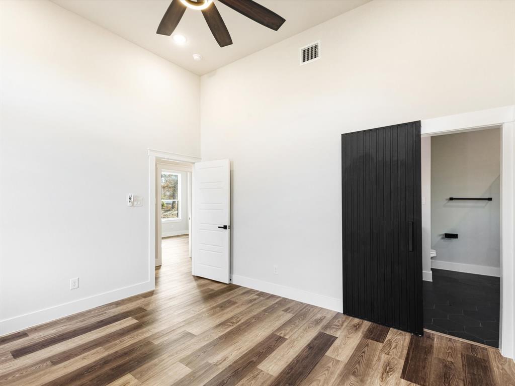 5018 Point La Vista Road Malakoff, TX 75148 - Photo 20 of 32 Unfurnished room featuring a high ceiling, wood finished floors, and a ceiling fan