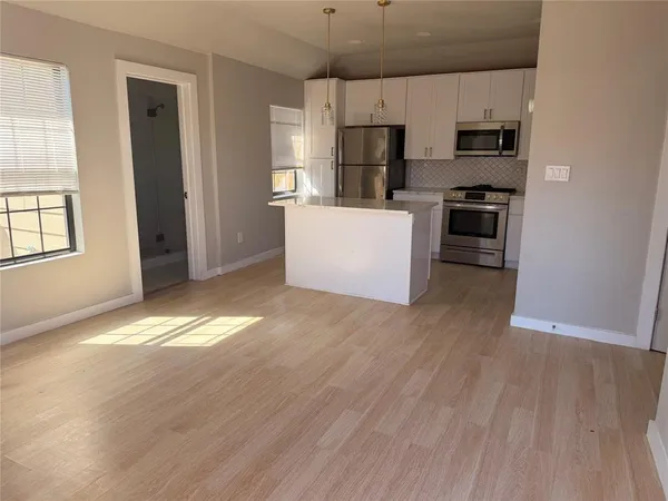 a kitchen with stainless steel appliances a refrigerator and a stove top oven