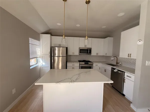 a kitchen with stainless steel appliances a stove refrigerator sink and microwave