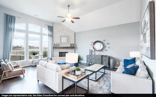 a living room with furniture fireplace and a large window