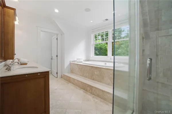a bathroom with a granite countertop sink a mirror and a shower