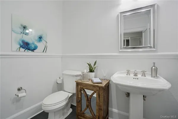 a bathroom with a sink a toilet and mirror