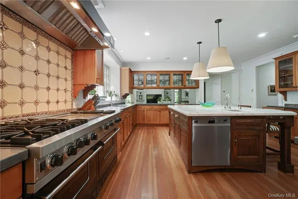 a kitchen with stainless steel appliances granite countertop a stove and a wooden floors