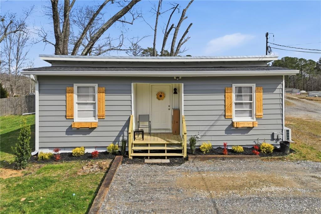 a view of a house with a small yard and wooden fence