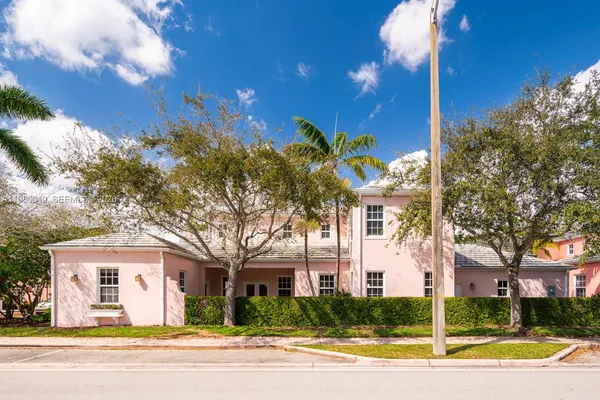 a view of a white building with a palm tree