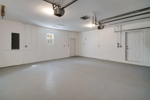 an empty room with a ceiling fan and windows