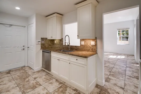 a kitchen with granite countertop a sink and cabinets