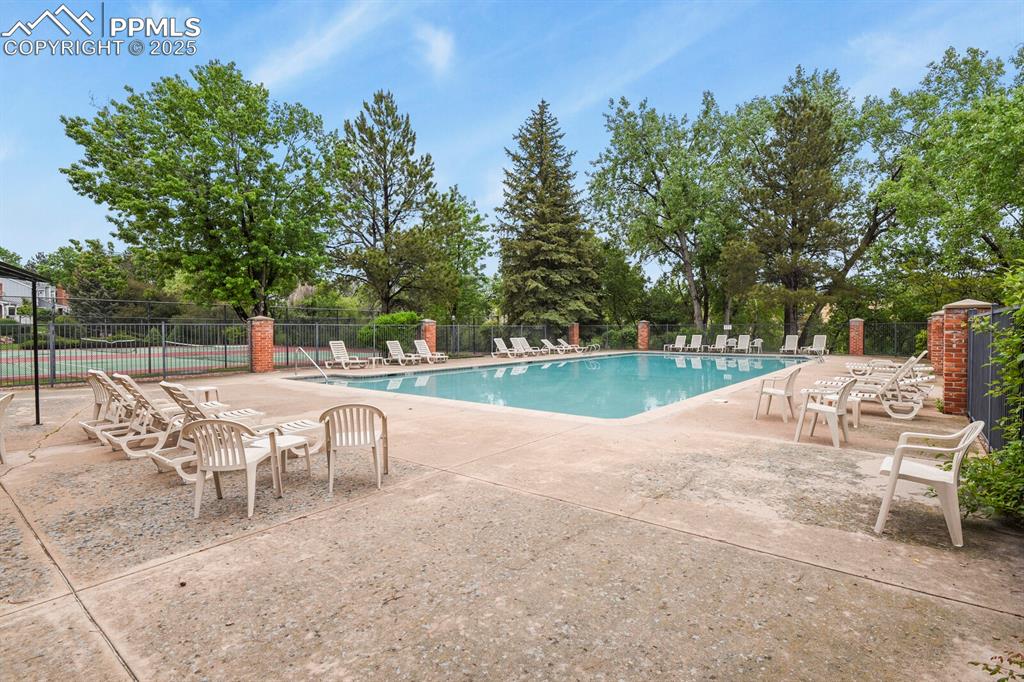6868 Los Reyes Circle Colorado Springs, CO 80918 - Photo 44 of 47 a view of a patio with table and chairs and potted plants with wooden fence