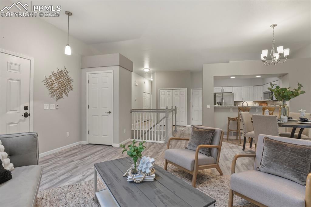 6868 Los Reyes Circle Colorado Springs, CO 80918 - Photo 8 of 47 a living room with furniture kitchen and a chandelier