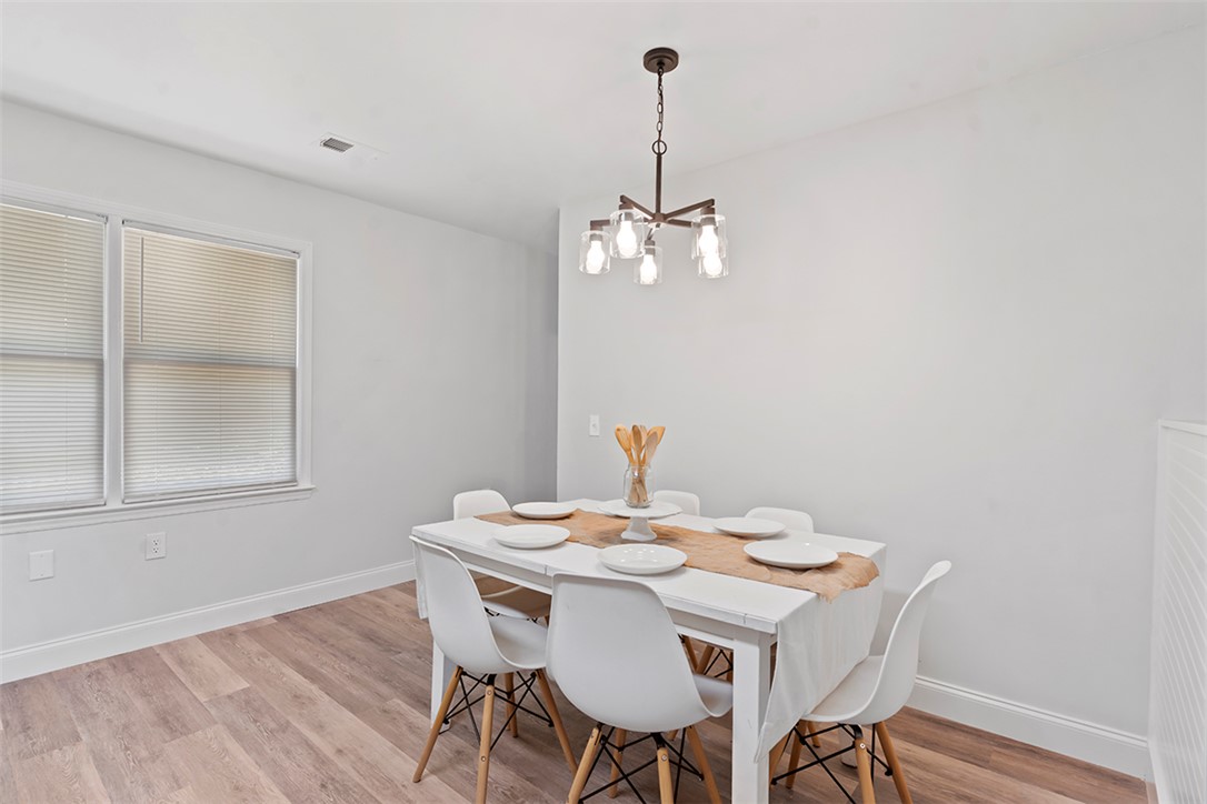 701 Quarry Street Anderson, SC 29624 - Photo 10 of 16 A refined dining room with natural wood flooring and a modern chandelier illuminates family meals.