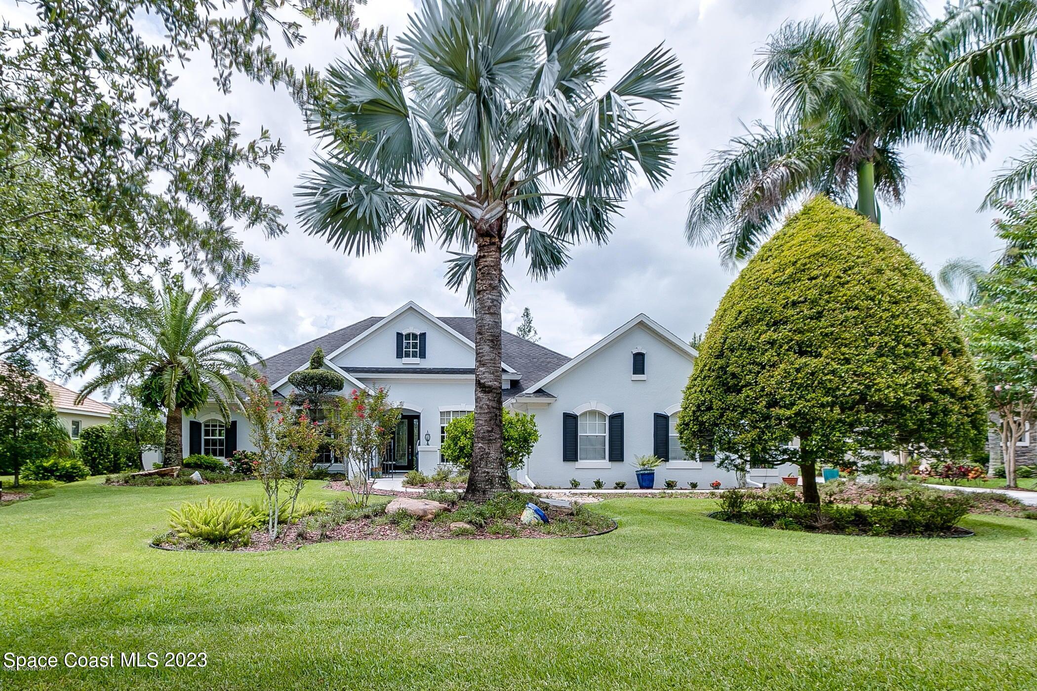 1840 Winding Ridge Circle Southeast Palm Bay, FL 32909 - Photo 1 of 41 a front view of a house with a garden and trees